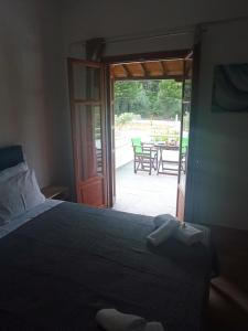 a bedroom with a bed and a door to a patio at Villa Sandra in Panormos Skopelos