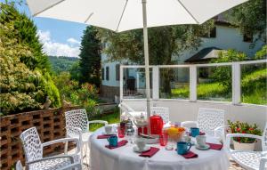 una mesa blanca con sombrilla en el patio en Awesome Home In Saludecio With Wifi, en Saludecio