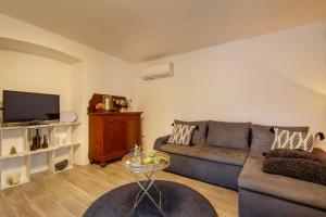 a living room with a couch and a tv at Apartments Kleine Perle Am Meer in Šilo