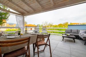 a patio with a table and chairs and a couch at Apartments Kleine Perle Am Meer in Šilo