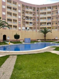 an empty swimming pool in front of a large building at Уютные апартаменты с боковым видом на море in Torrevieja