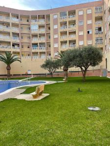 a large apartment building with a park in front of a building at Уютные апартаменты с боковым видом на море in Torrevieja