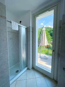 ein Bad mit einer Dusche und einem Sonnenschirm in der Unterkunft La Spiaggia Apartment in Bellagio