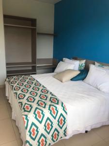 uma cama grande num quarto com uma parede azul em São Pedro Resort em Piracicaba