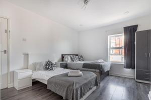 2Bedrooms, 4beds cosy family home, Free WiFi, Stay UK Homes في برمنغهام: غرفة بيضاء بسريرين واريكة