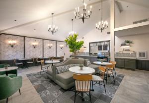 a lobby with tables and chairs and a kitchen at Cottage Inn by the Sea in Pismo Beach