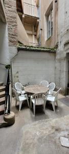 a wooden table and chairs sitting next to a building at Des Histoires d'Anges - Côté Ville - 2 meublés classés - Accueil Vélo in Tournus