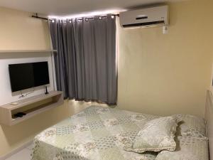 1 dormitorio con 1 cama y TV de pantalla plana en Atlantis Aquamarine, en João Pessoa