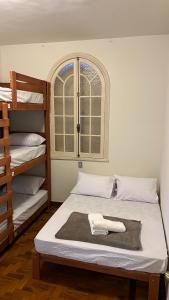 a bedroom with two bunk beds and a window at Nuh Hostel - Lourdes in Belo Horizonte