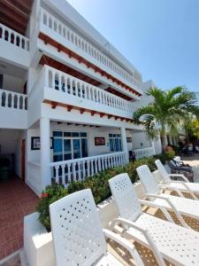 une rangée de chaises devant un bâtiment dans l'établissement hotel 3 banderas Manzanillo del Mar, à Carthagène des Indes