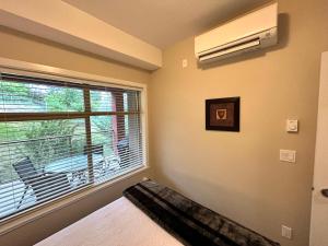 a bedroom with a bed and a window with a air conditioner at Stay In The Okanagan - Copper Sky, West Kelowna in West Kelowna