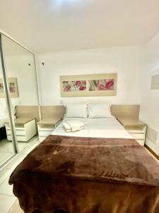 a bedroom with a large bed and a large mirror at Flat 309 Life beira lago in Brasilia
