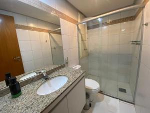 a bathroom with a sink and a toilet and a shower at Flat 309 Life beira lago in Brasilia