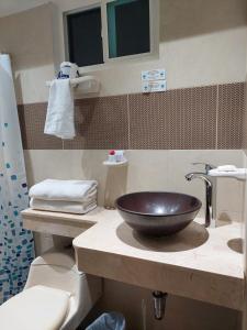 y baño con lavabo y aseo. en hotel 3 banderas Manzanillo del Mar en Cartagena de Indias