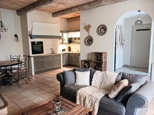 een woonkamer met een bank en een keuken bij Magnifiques maisons de campagne au sein d'un vignoble in Cazouls-lès-Béziers