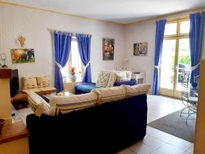 een woonkamer met een bank en blauwe gordijnen bij Magnifiques maisons de campagne au sein d'un vignoble in Cazouls-lès-Béziers