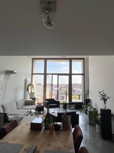 ein Wohnzimmer mit einem Sofa und einem großen Fenster in der Unterkunft Penthouse In the Center of Antwerp With private Elevator. in Antwerpen