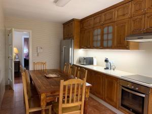 a kitchen with a wooden table and wooden cabinets at Home Sweet Home in Caldas de Reis