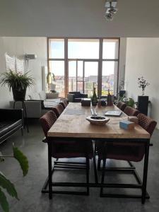 ein Wohnzimmer mit einem Holztisch und Stühlen in der Unterkunft Penthouse In the Center of Antwerp With private Elevator. in Antwerpen