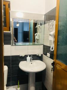 uma casa de banho com um lavatório, um espelho e um WC. em Guesthouse Jasmine em Ksamil