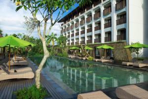 a hotel with a swimming pool with chairs and umbrellas at Element Bali Ubud in Ubud