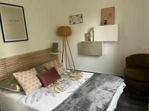 um quarto com uma cama com almofadas e uma cadeira em Villa ALISA avec piscine privée em Roquebrune-sur-Argens