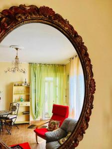 espejo en la sala de estar con sofá y silla en La Casa dei Panorami, en Castelsaraceno