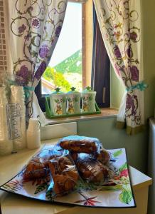 un plato de comida en una mesa frente a una ventana en La Casa dei Panorami, en Castelsaraceno