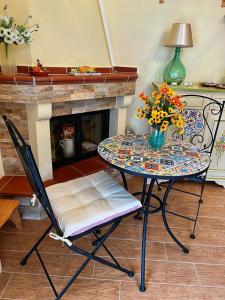 a table and chair with a vase of flowers on it at La Casa dei Panorami in Castelsaraceno