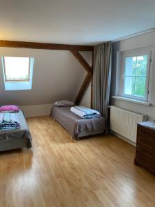 a bedroom with two beds and a wooden floor at Villa Panorama in Mirsk