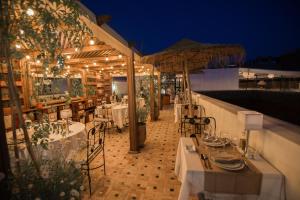 a restaurant with tables and umbrellas on a roof at Hotel & Spa Riad El Walaa in Marrakech