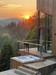 布伦纳Widokownia Brenna的一座房子,在甲板上设有小型游泳池,享有日落美景