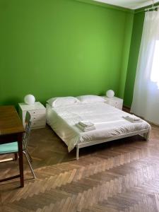 een groene slaapkamer met een bed en een tafel bij Casa Anna in Ravenna