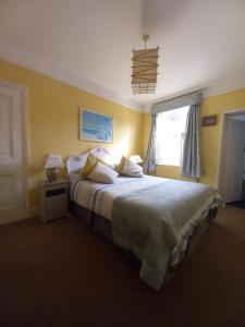 a bedroom with a large bed and a window at Seaview House in Thurlestone