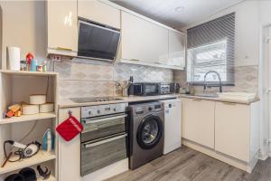 a kitchen with a washing machine and a sink at 2Bedrooms, 4beds cosy family home, Free WiFi, Stay UK Homes in Birmingham