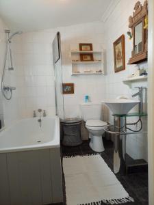 a bathroom with a tub and a toilet and a sink at Seaview House in Thurlestone