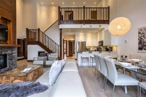 a living room with a couch and a dining room at Tremblant Prestige - Étoile 1500-5 in Mont-Tremblant