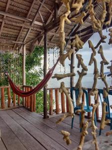a hammock on a deck with a view of the ocean at Amfriwen Homestay in Yennanas Besir