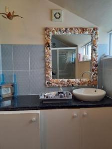 a bathroom with a sink and a mirror at Seaview House in Thurlestone