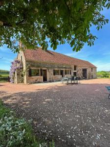 a stone building with a picnic table in front of it at La Maison de Barbara in La Guiche
