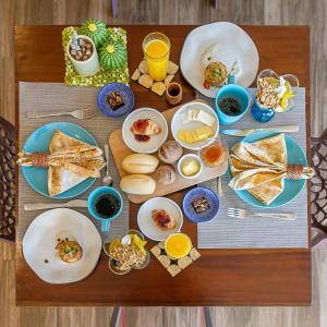 a table with plates of food on top at Shiva Boutique Hotel - Praia do Rosa in Praia do Rosa