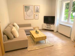 a living room with a couch and a coffee table at T2 Neuf, parking & garage privé, proche centre in Sarlat-la-Canéda