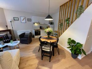 a kitchen and living room with a table and chairs at Sisley Cottage in Moret-sur-Loing