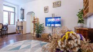 Family Holidays في براشوف: غرفة معيشة مع تلفزيون وورود على الأرض