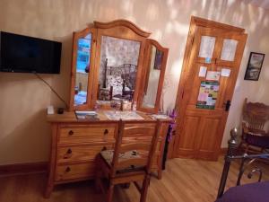 Habitación con tocador de madera y espejo. en Sessiagh House en Castlefinn