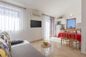 un salon avec un canapé et une table dans l'établissement Apartmani Anna, à Rogoznica