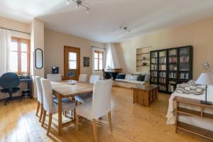 sala de estar con mesa de madera y sillas en Bougainvillea Tree House, en Chavriáta