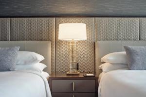 una habitación de hotel con 2 camas y una lámpara entre ellas en JW Marriott Hotel Monterrey Valle, en Monterrey
