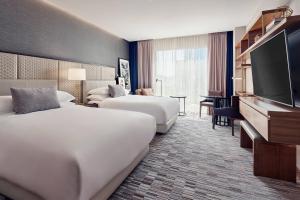 um quarto de hotel com duas camas e uma televisão de ecrã plano em JW Marriott Hotel Monterrey Valle em Monterrey