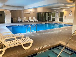 a pool with two lounge chairs and a hotel at Staybridge Suites Great Falls by IHG in Great Falls